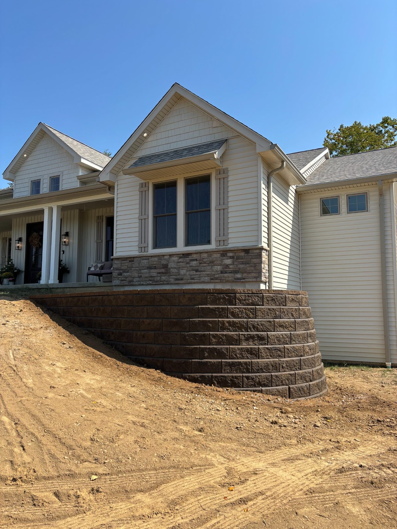 Completed retaining wall and graded landscape beside a home